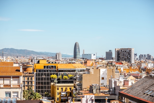 Вид на горизонт с башней Агбар, жилыми домами и горами на заднем плане в городе Барселона