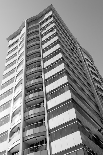 Skyscraper building with balcomies, in black and white .