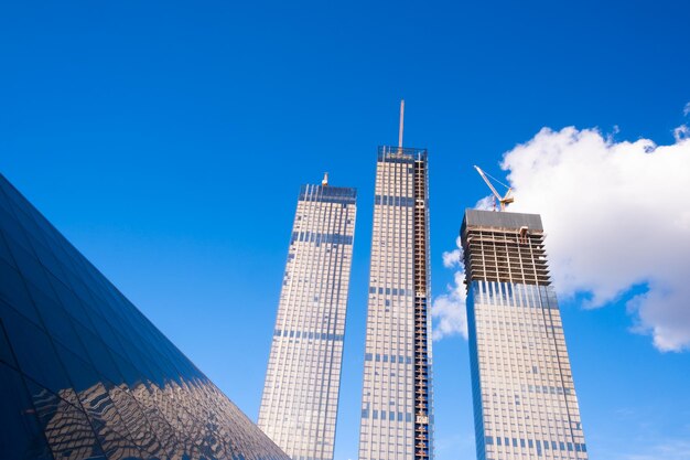 Facciate di vetro del grattacielo in una luminosa giornata di sole con raggi di sole nel cielo blu. economia, finanze, concetto di attività di sviluppo aziendale. vista dal basso