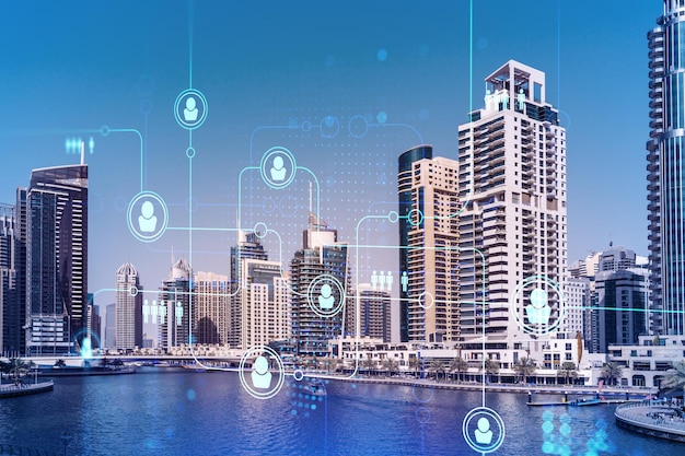 Skyscrapers of Dubai business downtown International hub of trading and financial services Social network icons hologram concept of human resources Double exposure Dubai Canal waterfront