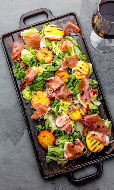 Sla, ham serrano en gegrilde perziken salade