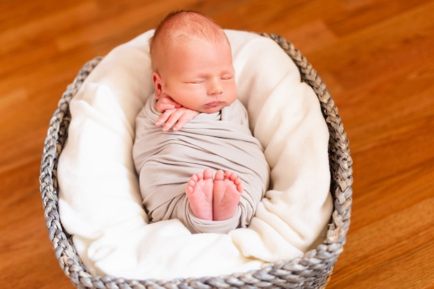 Slaap pasgeboren baby in de grijze mand