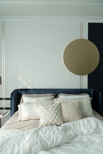Slaapkamer hoek marineblauw fluwelen bed met zachte kussens gedecoreerd met ronde marmeren nachtkastje en marineblauwe verfmuur
