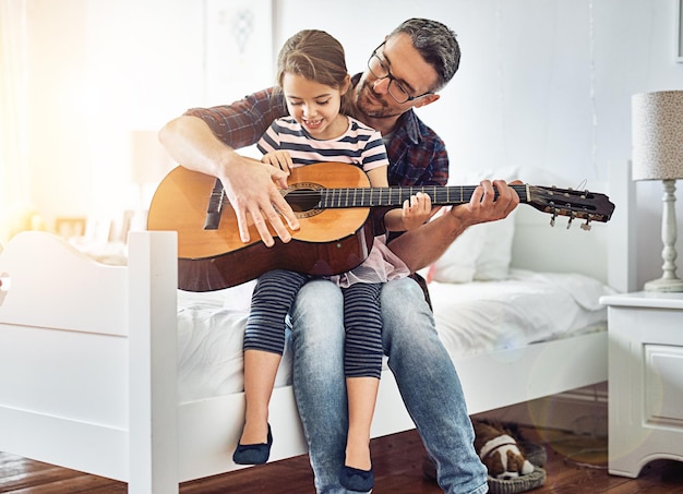 Slaapkamer lesgeven en gitaar spelen met vadermeisje voor de lol met muziek in huis voor hechting Instrumentakoestiek en leren met ouderkind in kamer met geluk of liefde of creativiteit thuis