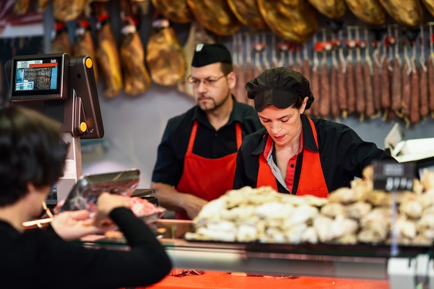 Slagers bijwonen van een klant in een slagerij