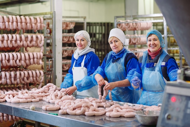 Slagers die worsten verwerken bij vleesfabriek.