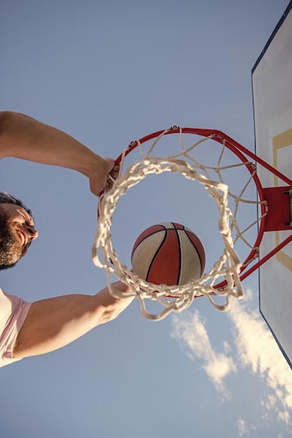 Slam dunk in beweging bovenaanzicht zomeractiviteit man met basketbalbal op de baan