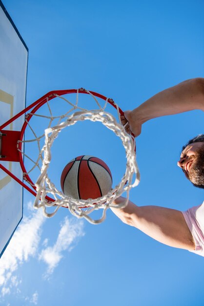 Slam dunk in beweging bovenaanzicht zomeractiviteit man met basketbalbal op de baan
