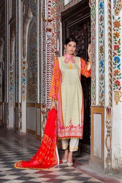 Slank meisje poseren met houding in traditionele Desi-jurk op oude plek voor fotoshoot