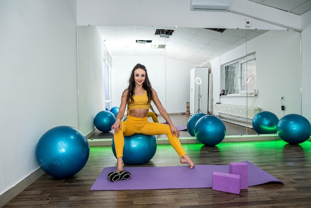 Slank opgepompt meisje met een geweldige pers traint haar conditie terwijl ze aan fitness doet in de sportschool