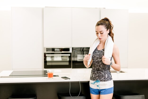 Slanke fitness vrouw thuis uit te werken met muziek van de telefoon