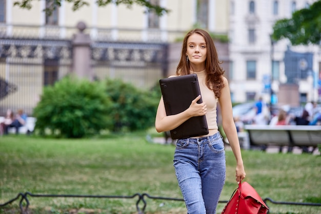 Slanke jarige student kwam parkeren met laptop