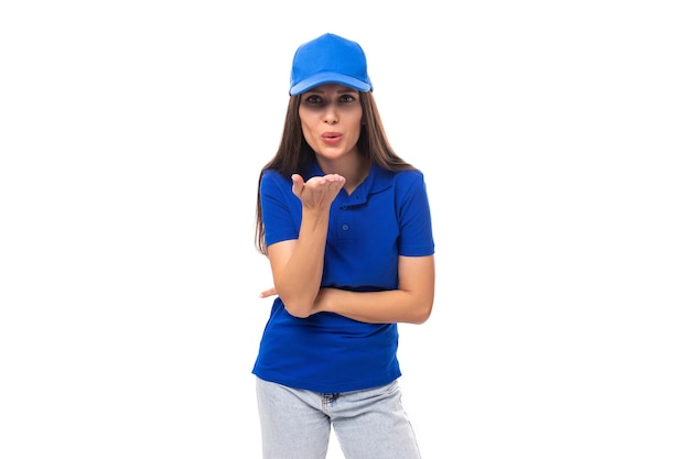 Slanke mooie jonge blanke brunette adverteerder vrouw in lege blauwe t-shirt en pet om af te drukken