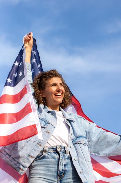 Foto slanke mooie vrouw die de vlag van de v.s. houdt