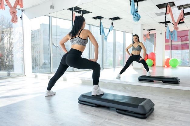 Slanke vrouw abs training streching in een fitnessruimte. Gezonde levensstijl