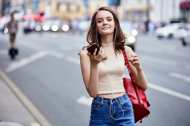 Slanke vrouw belt met smartphone in de buurt van verkeer