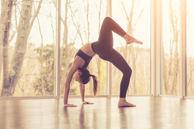 Slanke vrouw die yoga in studio doet