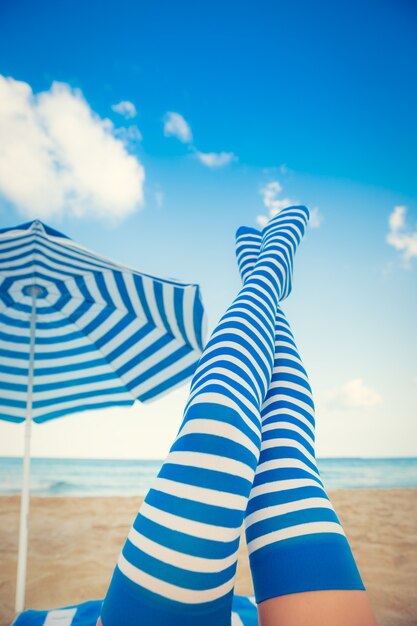 Slanke vrouwenbenen op een strand. Zomervakantie en reisconcept