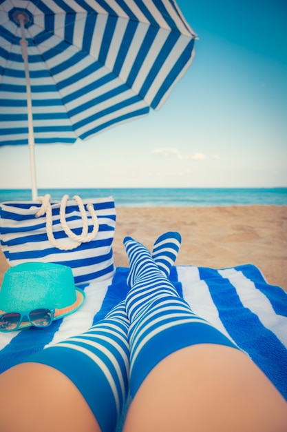 Slanke vrouwenbenen op een strand. Zomervakantie en reisconcept