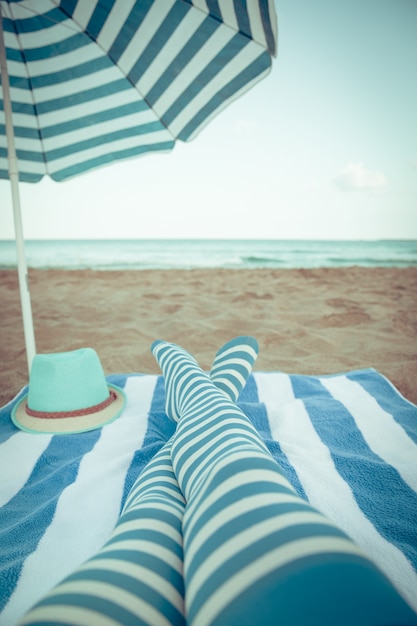 Slanke vrouwenbenen op een strand. Zomervakantie en reizen concept. Retro