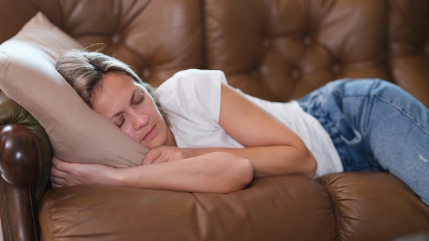 Slapende luie vrouw ligt overdag op de bank