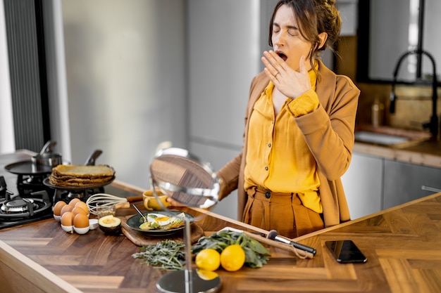 Slaperige bisnessvrouw in de keuken vroeg in de ochtend