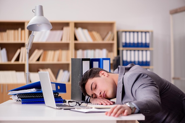 Slaperige zakenman die in bureau werkt
