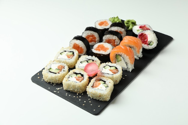 Slate board with sushi set on white background