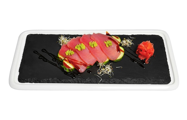 Slate plate with delicious tuna sashimi on white background