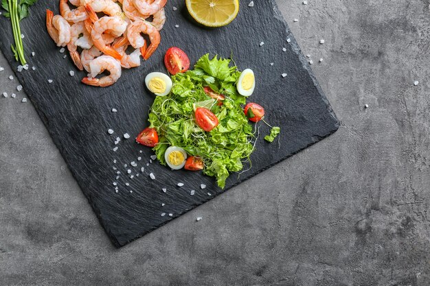 Slate plate with fresh tasty shrimp salad on table