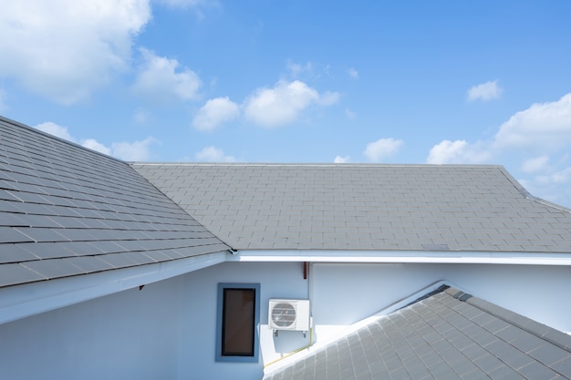 Slate roof against blue sky, Gray tile roof of construction house with blue sky and cloud