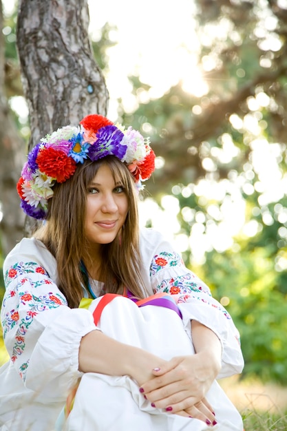 Slav girl with wreath at field.