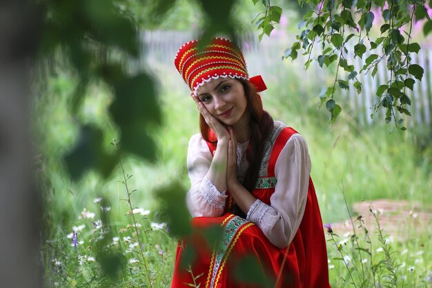 Slav in traditional dress is sitting in nature