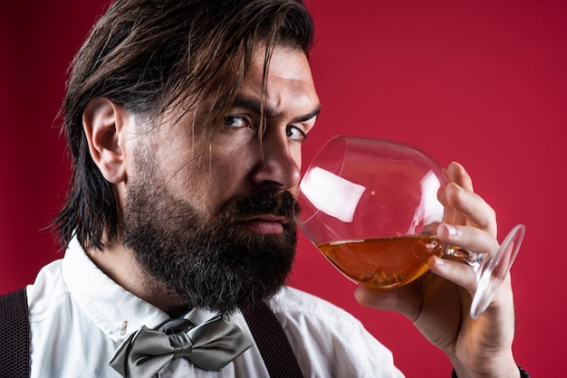 Slechts één slok brutale knappe man met snor volwassen man met whisky mannelijkheid en charisma formele feestkledingvoorschrift ouderwetse bebaarde hipster drank cognac alcoholverslaafde concept