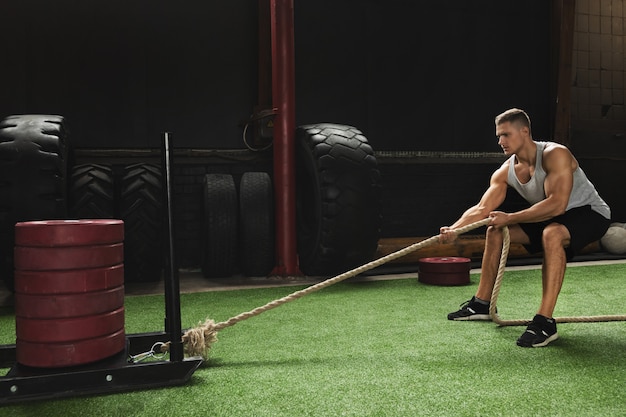 Sled drag exercise. Sportsman during his cross training workout.