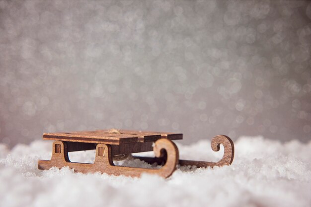 Sled on snow on glitter festive background. 