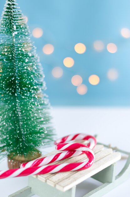 Sledge with sweets and Christmas tree with lights.