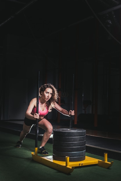 Slee push vrouw duwen gewichten training oefening