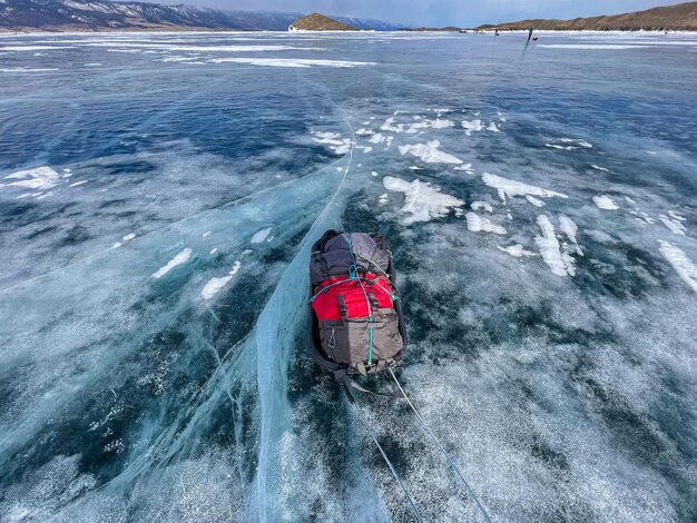 Foto slee slepen op het bevroren ijs van het baikalmeer wintertrekking