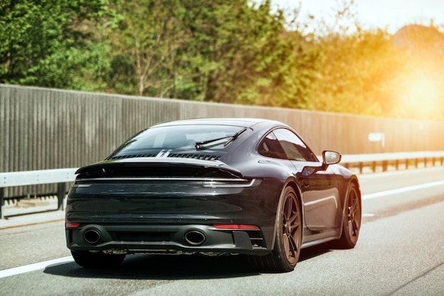 Sleek Black German Roadster Brand New Luxury Carrera Sports Car on the Highway Rear view of the 911 GTS sports car