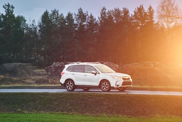 sleek modern crossover car speeds along an asphalt road