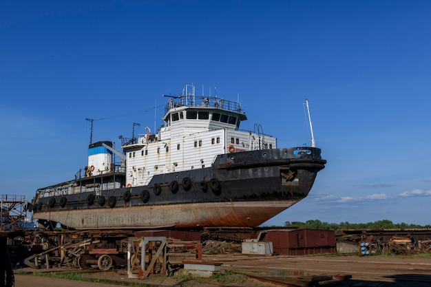 Sleepboot aan wal op scheepsreparatiewerf