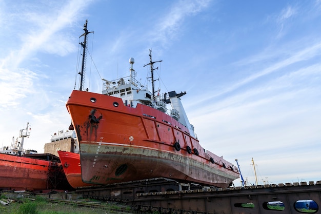 Sleepboot aan wal op scheepsreparatiewerf