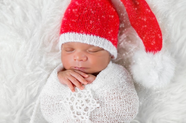 Sleeper newborn baby in a Christmas Santa cap