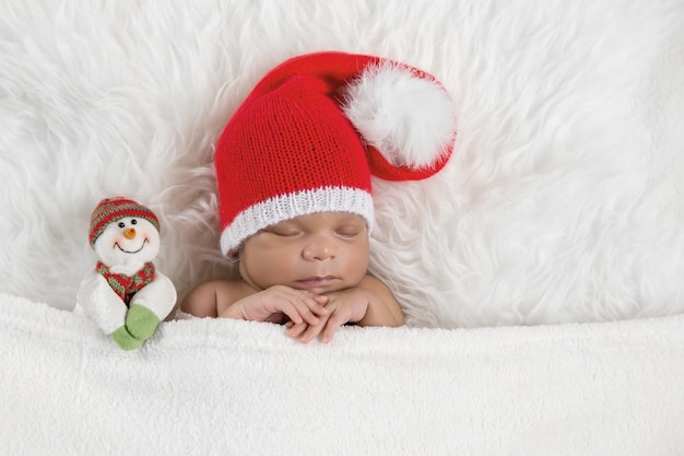 Sleeper newborn baby in a Christmas Santa cap