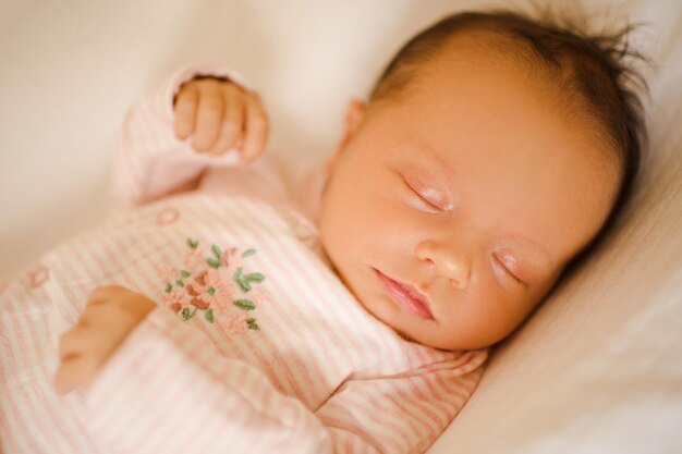 Sleeping baby girl with closed eyes wear pajamas lying in crib close up Childhood