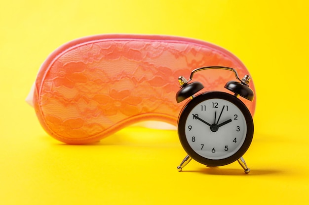 Sleeping eye mask alarm clock isolated on yellow colourful trendy modern fashion background Do not disturb me let me sleep Rest good night siesta insomnia relaxation tired travel concept