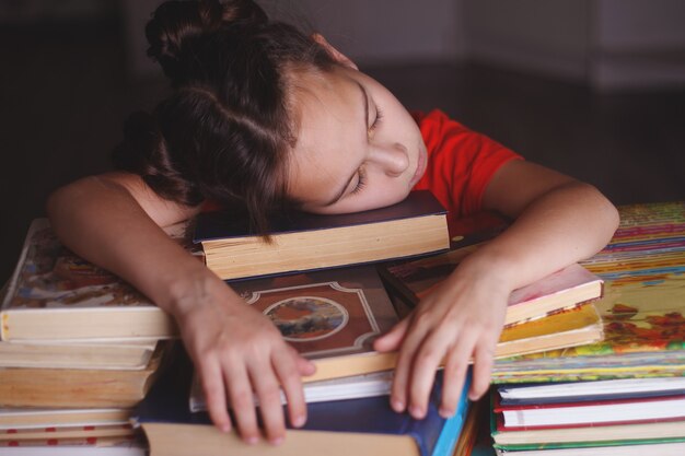 Sleeping girl with piles of books