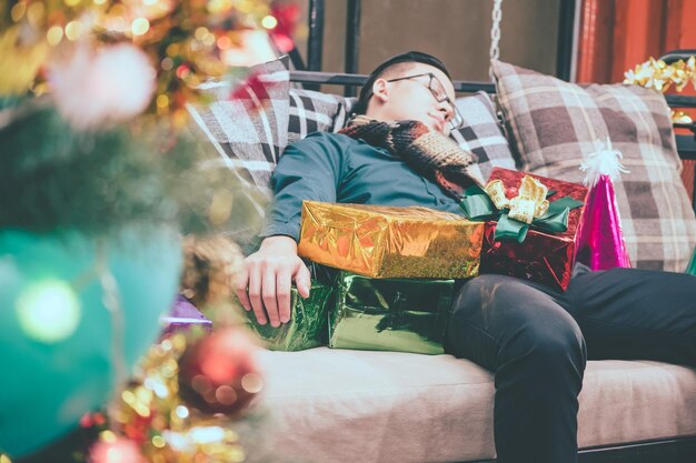 写真 クリスマスパーティーの後、ソファで寝ている男性