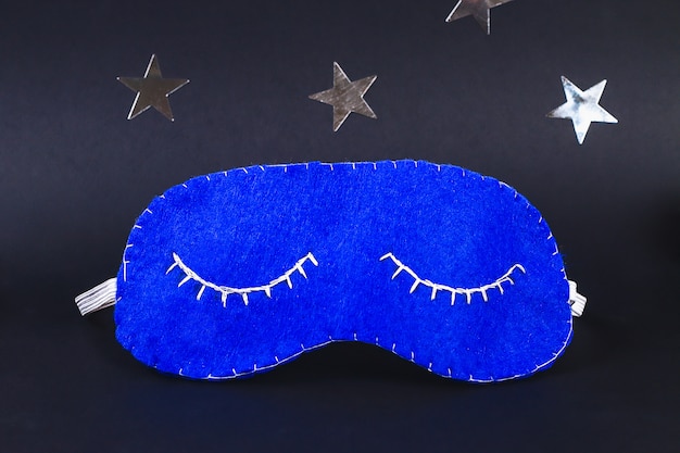 Sleeping mask handmade made of felt, stars on a black background.